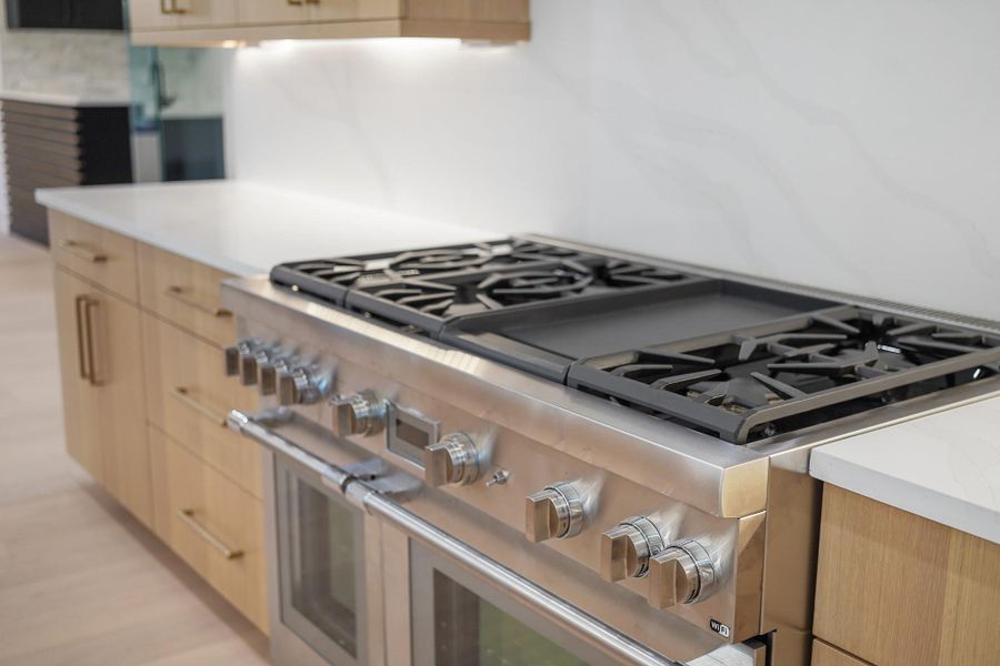 Six burners and a center griddle top the two ovens in this commercial grade Thermador range. The powerful overhead vent is also a Thermador.