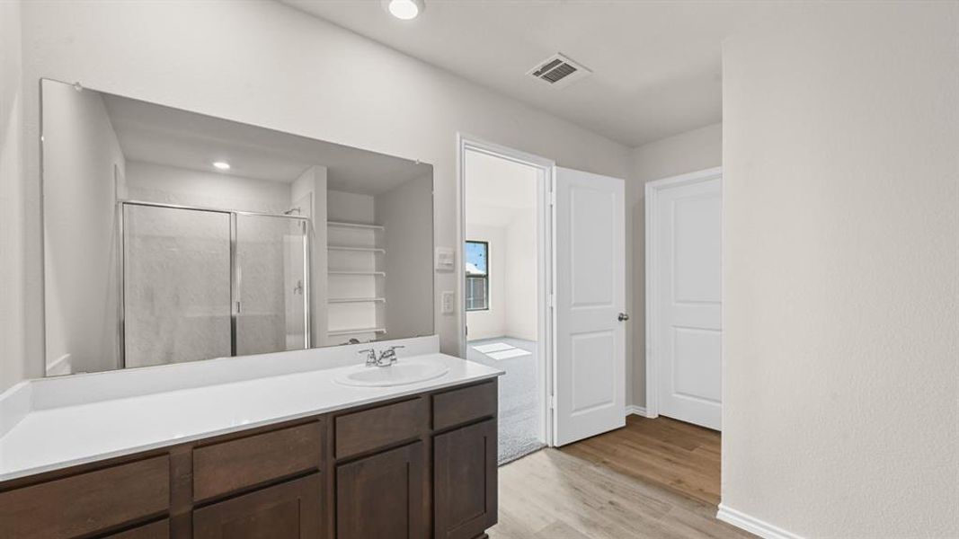 Dark wood-finish vanity with a white countertop and integrated sink Dark wood-finish vanity with a white countertop and integrated sink
