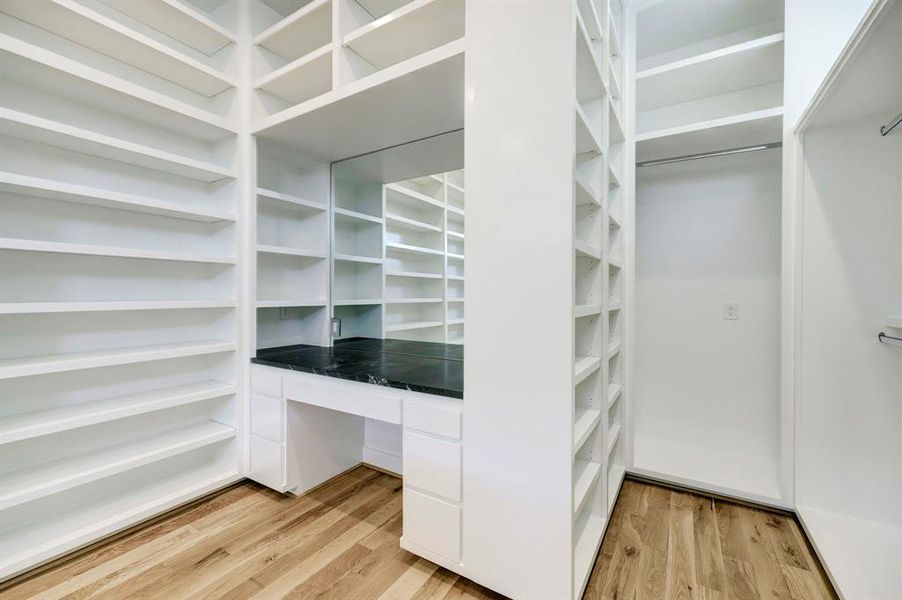 Massive primary closet with dressing table and dual packing islands