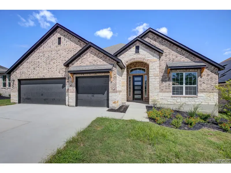 Front exterior of a new home in The Reserve at Potranco Oaks, Castroville, TX, highlighting curb appeal (Image 1).