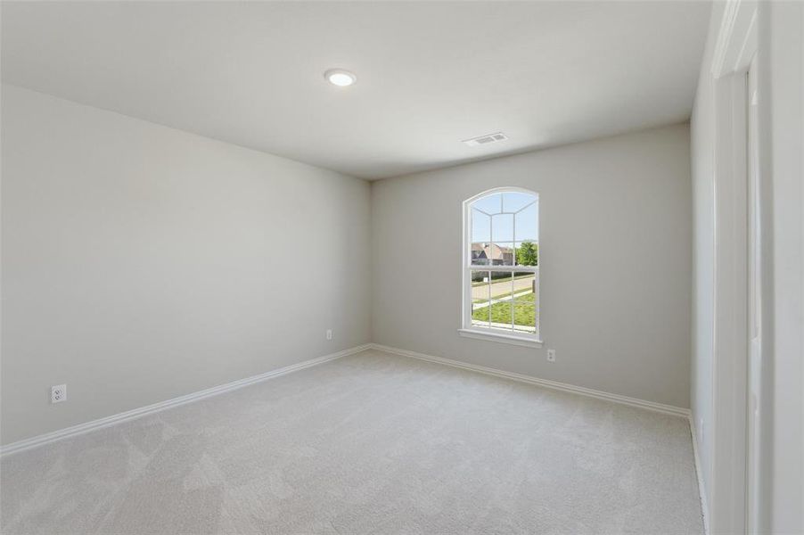 Spare room featuring light carpet and baseboards