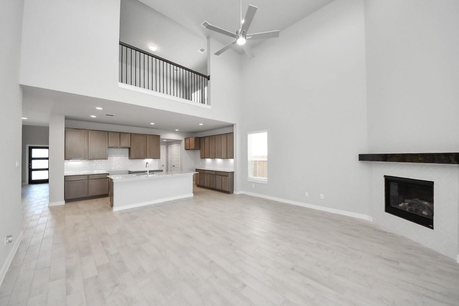 Relax and unwind in this inviting family room, illuminated by abundant natural light streaming in through tall windows, complemented by high ceilings and stunning flooring. Stay comfortable year-round with the gentle breeze from the ceiling fan, creating the perfect atmosphere for family gatherings. Sample photo of completed home with similar floor plan. Actual colors and selections may vary.