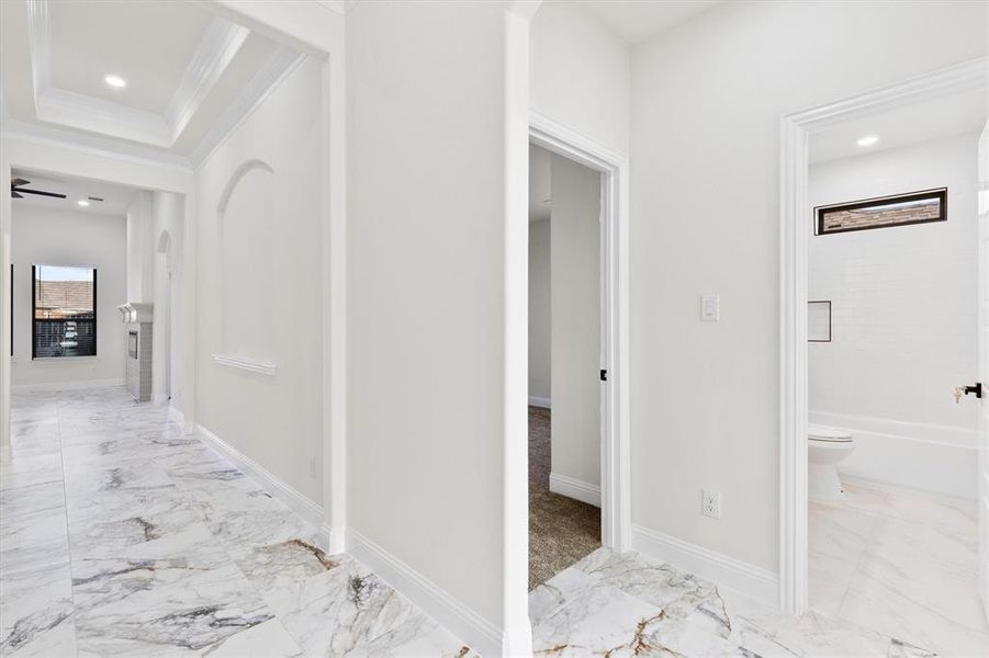 Hallway with ornamental molding, recessed lighting, marble finish floor, and baseboards Hallway with ornamental molding, recessed lighting, marble finish floor, and baseboards