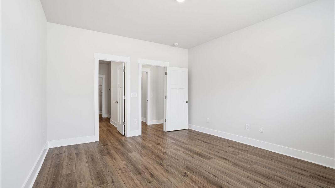 Serene and stylish primary bedroom featuring hardwood flooring and a thoughtful, modern layout near Downtown Anderson Serene and stylish primary bedroom featuring hardwood flooring and a thoughtful, modern layout near Downtown Anderson