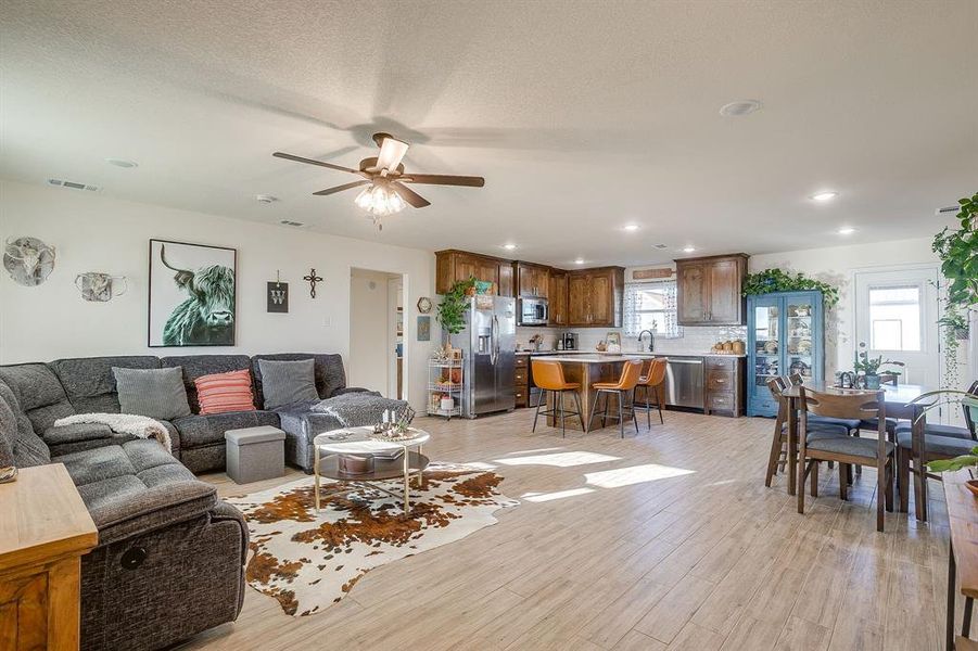 Living room featuring recessed lighting, light wood-style tile flooring, and ceiling fan Living room featuring recessed lighting, light wood-style tile flooring, and ceiling fan