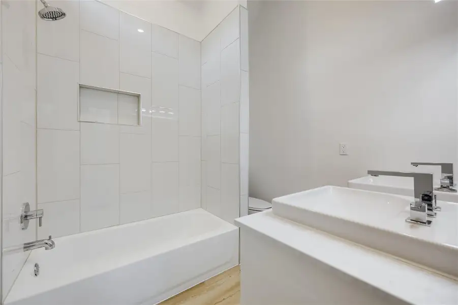 Full bathroom with shower / washtub combination, vanity, and light wood-type flooring Full bathroom with shower / washtub combination, vanity, and light wood-type flooring