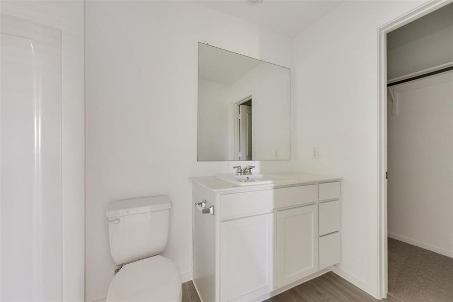 Bathroom with wood-type flooring, vanity, and toilet