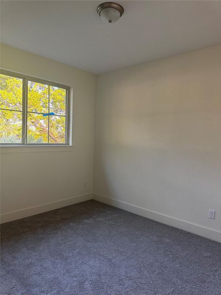 Empty room featuring dark carpet and baseboards Empty room featuring dark carpet and baseboards