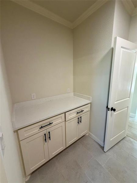 Bathroom with crown molding, vanity, and light tile patterned flooring Bathroom with crown molding, vanity, and light tile patterned flooring