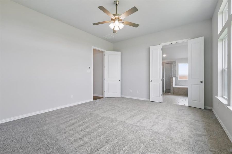 Unfurnished bedroom with carpet floors, baseboards, ensuite bath, and ceiling fan Unfurnished bedroom with carpet floors, baseboards, ensuite bath, and ceiling fan