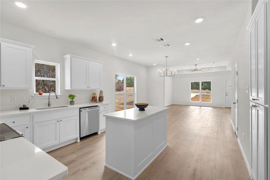 Kitchen with white cabinets, plenty of natural light, open floor plan, a center island, and recessed lighting Kitchen with white cabinets, plenty of natural light, open floor plan, a center island, and recessed lighting
