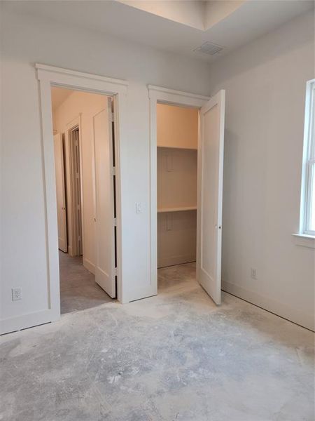 Unfurnished bedroom with a closet and a walk in closet