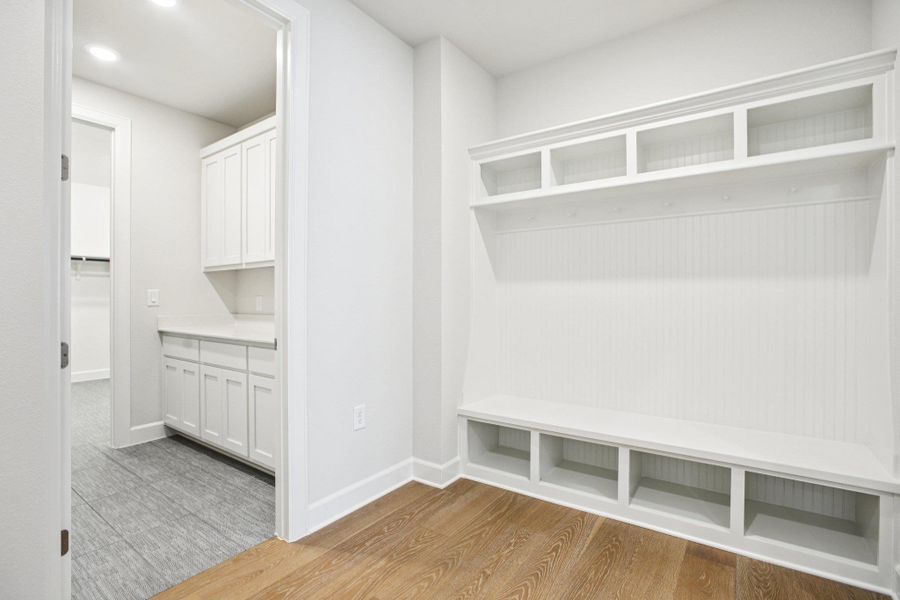 Mudroom with light wood-style flooring and baseboards