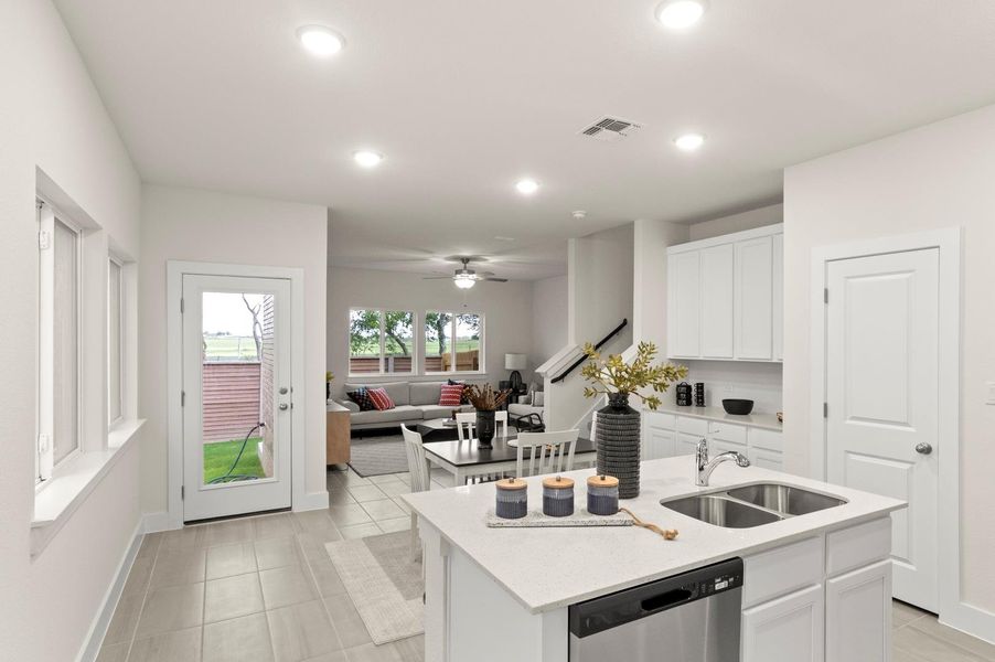 A seamless open-concept design connects a modern kitchen to a comfortable living area, ideal for daily living and entertaining.