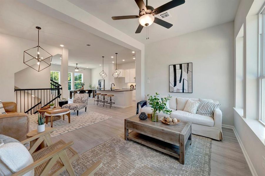 Open-concept living space featuring wood-finish flooring, recessed lighting, and a contemporary ceiling fan