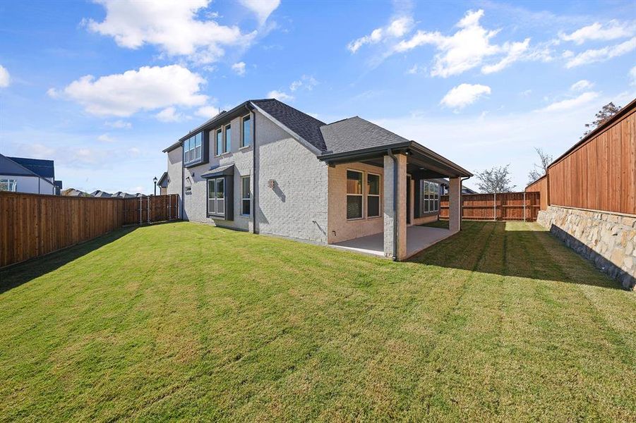 Back of property with a patio, a fenced backyard, and brick siding Back of property with a patio, a fenced backyard, and brick siding