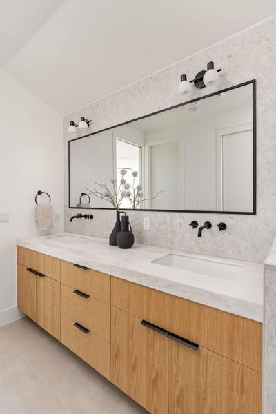 Bathroom with double vanity and light tile patterned floors