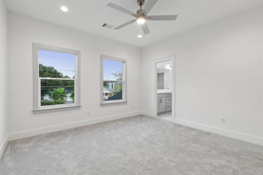 Carpeted empty room featuring ceiling fan