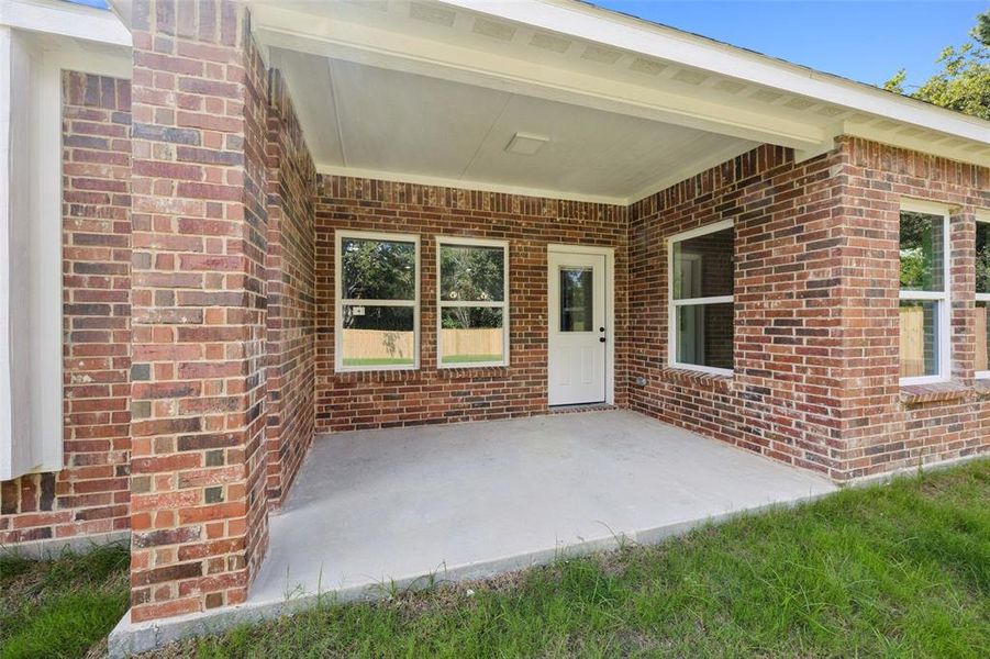 View of exterior entry with brick siding and a patio View of exterior entry with brick siding and a patio