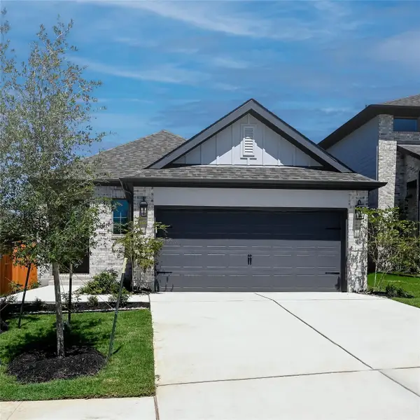 View of front facade featuring board and batten siding, a garage, driveway, and a shingled roof View of front facade featuring board and batten siding, a garage, driveway, and a shingled roof