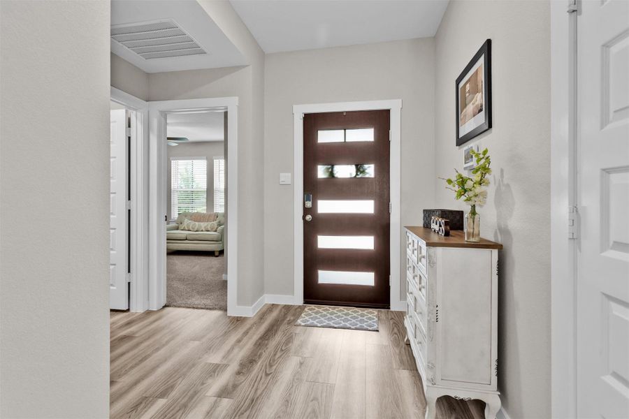 The modern front door with glass panels accent the entry.