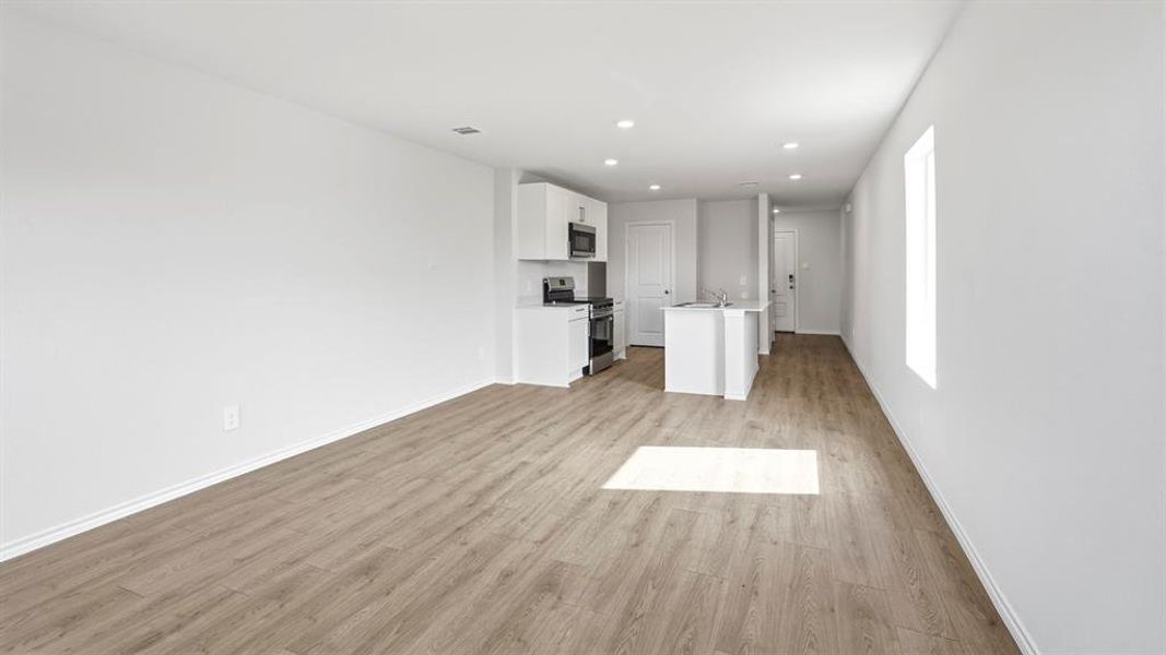Unfurnished living room featuring light wood-style floors and recessed lighting Unfurnished living room featuring light wood-style floors and recessed lighting