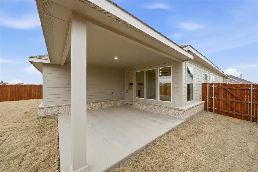 Back of property with a fenced backyard, a patio, and a gate