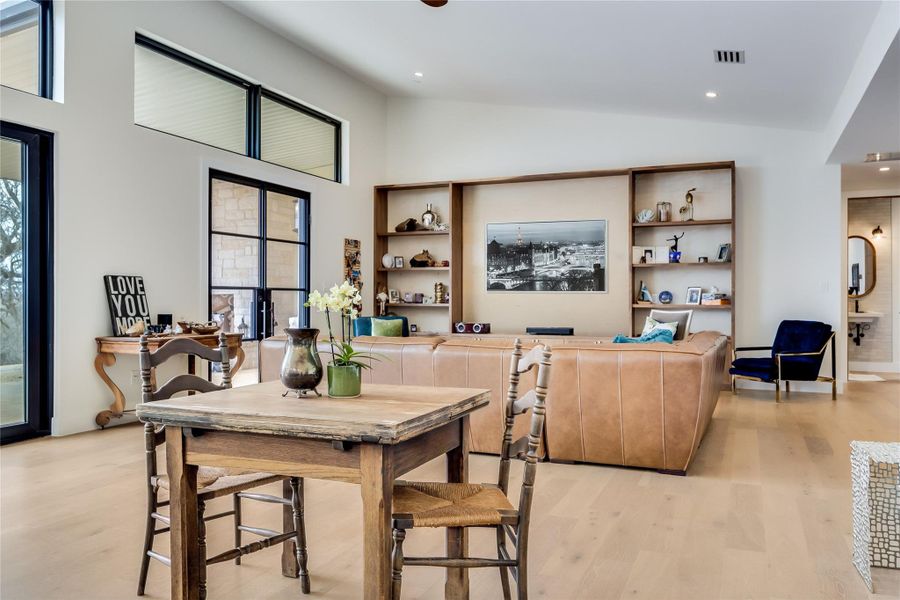 Dining room with lofted ceiling, light wood finished floors, and recessed lighting