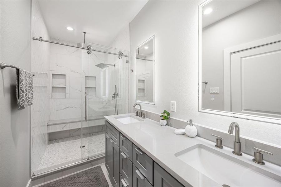 primary bathroom equipped with double vanity, large walk in shower and led mirrors