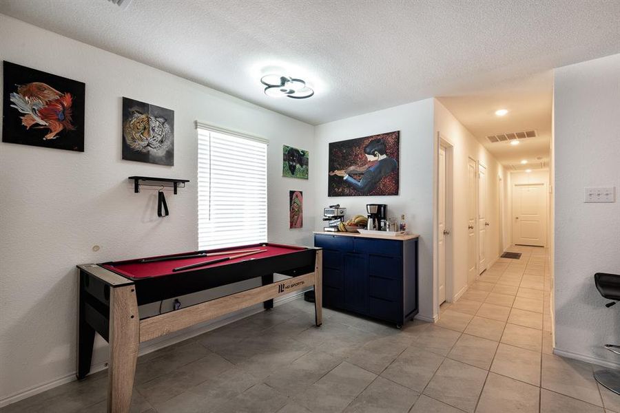 Rec room with a textured ceiling, light tile patterned floors, and billiards