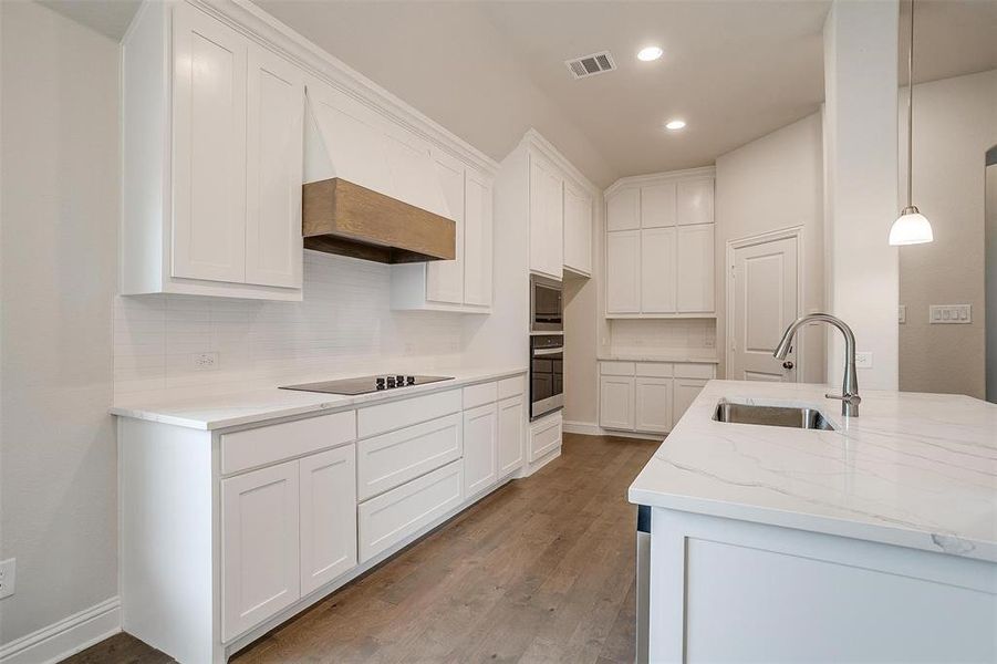 Kitchen with hardwood / wood-style floors, sink, and white cabinets