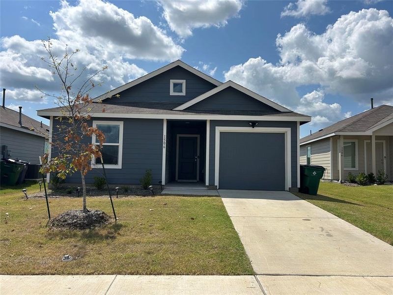 View of front of property featuring a garage and a front yard View of front of property featuring a garage and a front yard