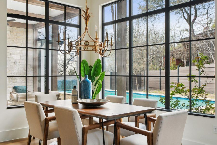 Dining space featuring a notable chandelier, a healthy amount of sunlight, and wood finished floors