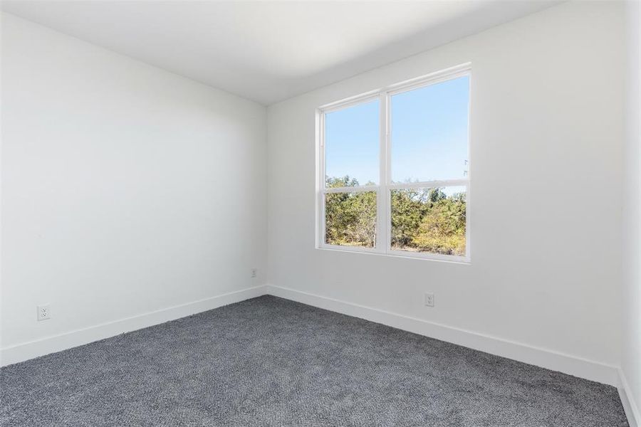Unfurnished room with baseboards and dark carpet Unfurnished room with baseboards and dark carpet