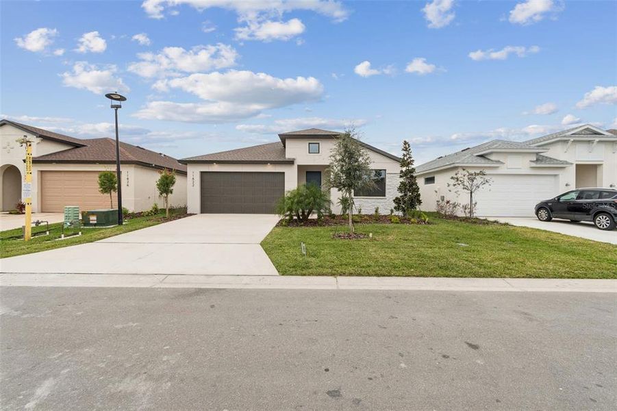 Front exterior of a new home in Isles at Bayview, Parrish, FL, highlighting curb appeal (Image 25). Front exterior of a new home in Isles at Bayview, Parrish, FL, highlighting curb appeal (Image 25).