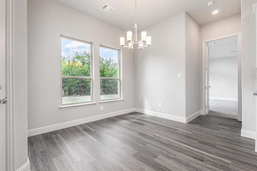 Spare room with dark wood-style flooring, a chandelier, and recessed lighting Spare room with dark wood-style flooring, a chandelier, and recessed lighting