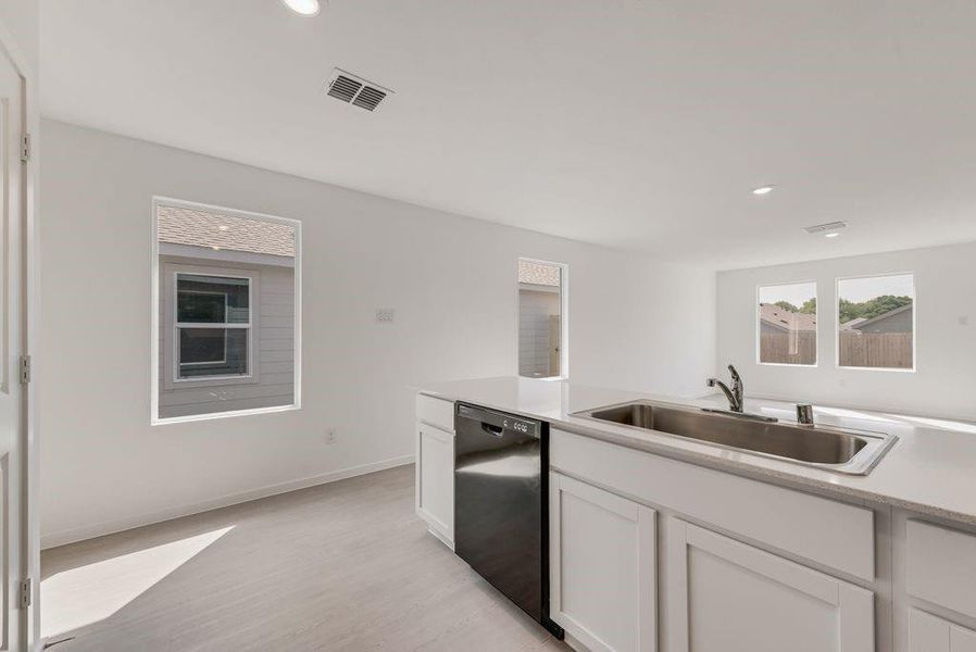 Kitchen featuring white cabinets, dishwasher, light wood-style floors, and recessed lighting
