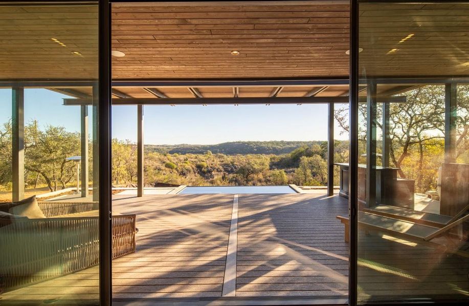 Doorway to outside with expansive windows, plenty of natural light, and wooden ceiling