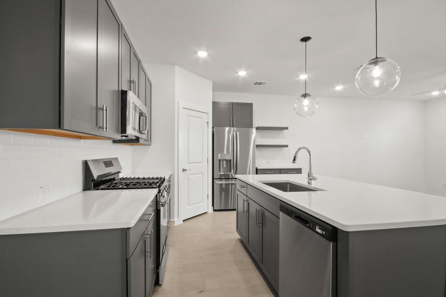 Gorgeous kitchen with quartz counters and stylish floating shelves (*Photo not of actual home and used for illustration purposes only.)