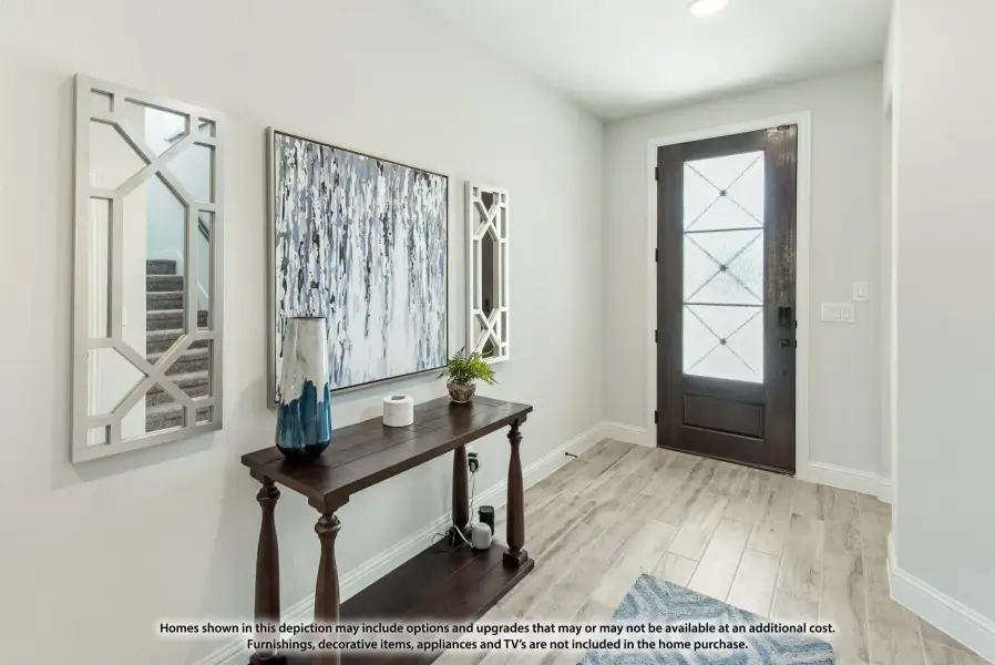 Entryway with dark wood front door, console table, wall art, and light wood-look floors Entryway with dark wood front door, console table, wall art, and light wood-look floors