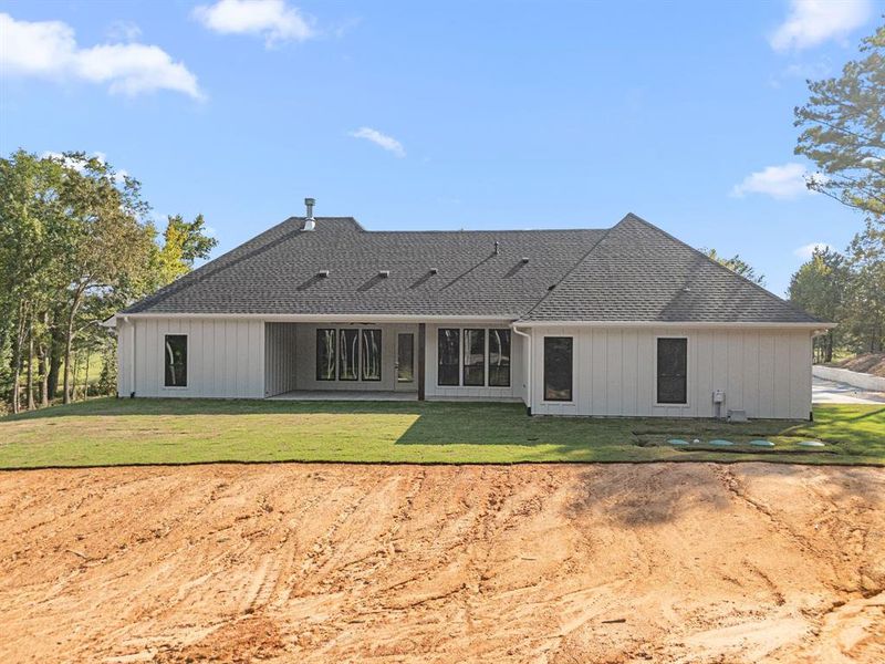 Back of house with a patio area, a yard, and roof with shingles