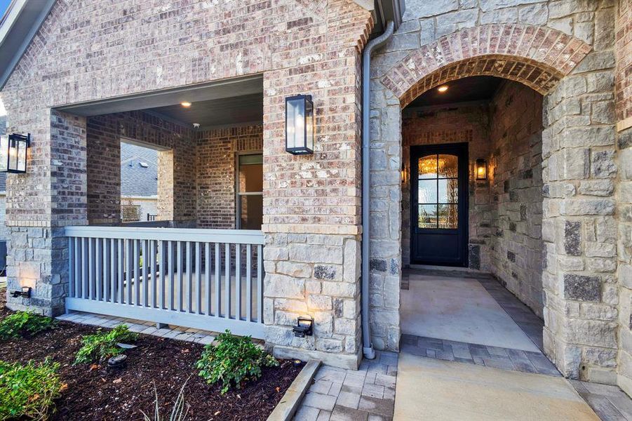 Entrance to property with stone siding and brick siding