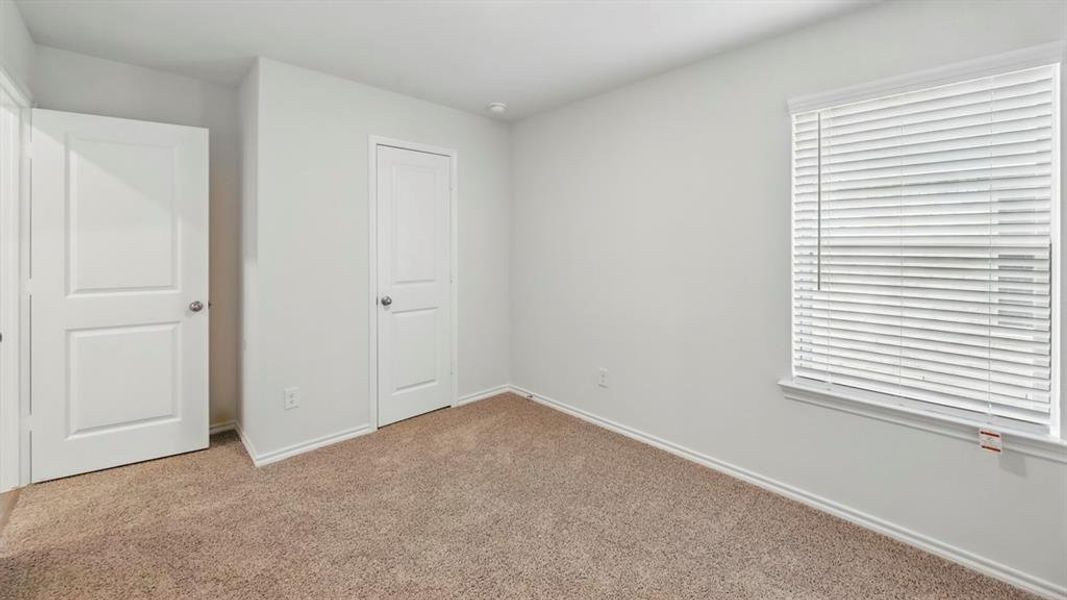 Unfurnished bedroom with carpet flooring and baseboards Unfurnished bedroom with carpet flooring and baseboards