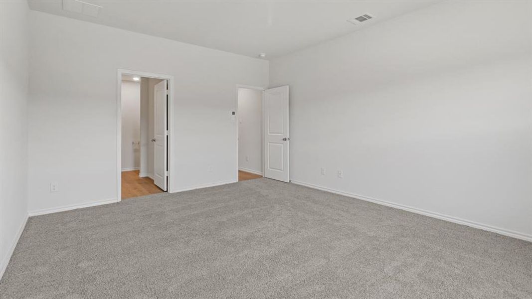 Spacious room featuring light gray carpeting and bright white walls