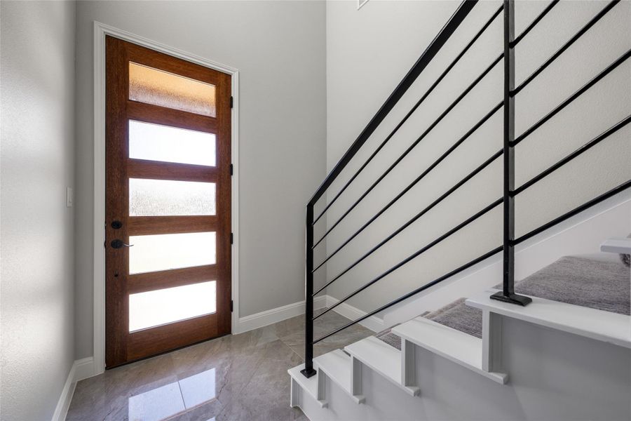 Foyer featuring stairs and light marble finish flooring