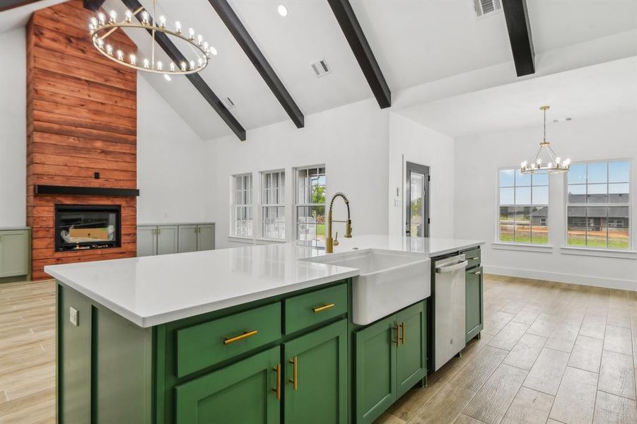 Kitchen with green cabinets, a chandelier, hanging light fixtures, a kitchen island with sink, and light wood finished floors Kitchen with green cabinets, a chandelier, hanging light fixtures, a kitchen island with sink, and light wood finished floors
