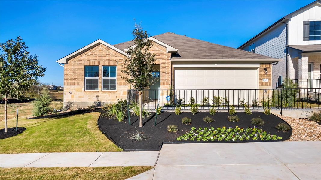 Front exterior of a new home in Carillon, Manor, TX, highlighting curb appeal (Image 24). Front exterior of a new home in Carillon, Manor, TX, highlighting curb appeal (Image 24).