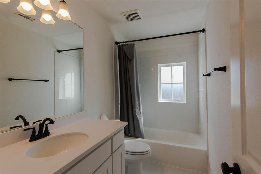 Full bathroom featuring tile patterned flooring, vanity, shower / bath combo, and toilet