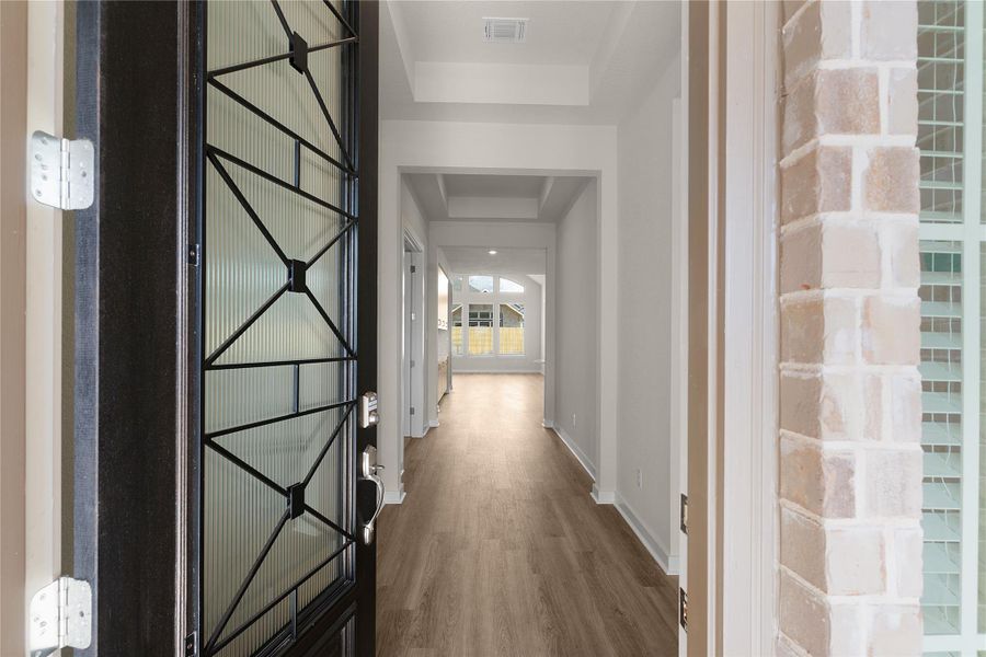 Corridor featuring dark wood-type flooring and a raised ceiling