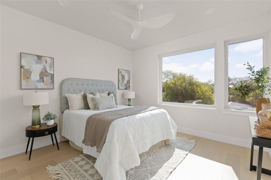 Hardwood floors and massive windows framing leafy views define this serene retreat.